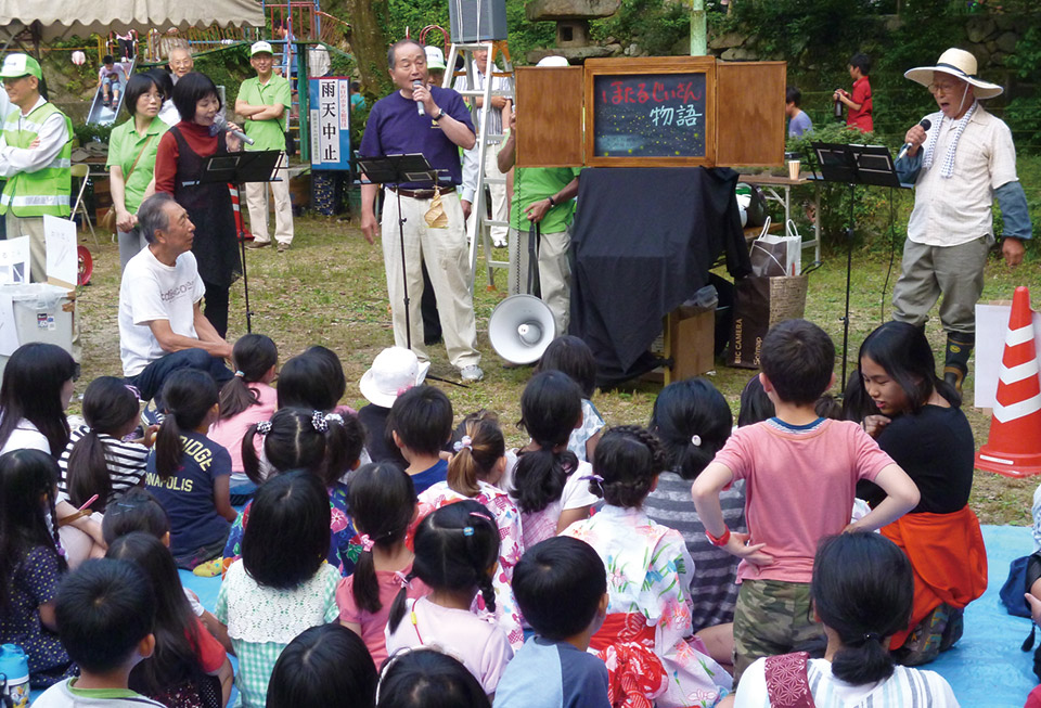 地元の子どもたちに向けて、オリジナル紙芝居『ホタルのひかるくんとおじいさんの物語』を上演している様子